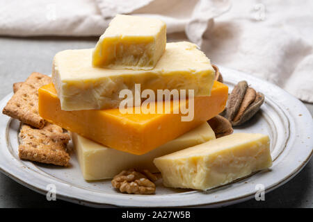 Käse Sammlung, gereift und orange original britischen Cheddar in Blöcke mit Crackers serviert Nahaufnahme Stockfoto