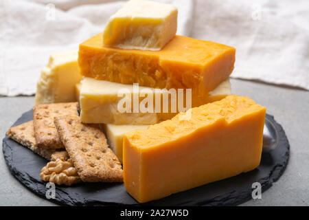 Käse Sammlung, gereift und orange original britischen Cheddar in Blöcke mit Crackers serviert Nahaufnahme Stockfoto