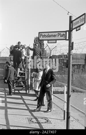Touristen schulmeisterschaft von einem Aussichtspunkt an der Ecke Potsdamer Platz und die Potsdamer Straße über die Mauer hinweg vom Ostteil in den Westteil von Berlin, Deutschland 1962. Touristen Blick von einem Aussichtspunkt an der Ecke Potsdamer Platz und die Potsdamer Straße über die Wand vom westlichen Teil in den östlichen Teil von Berlin, Deutschland 1962. Stockfoto