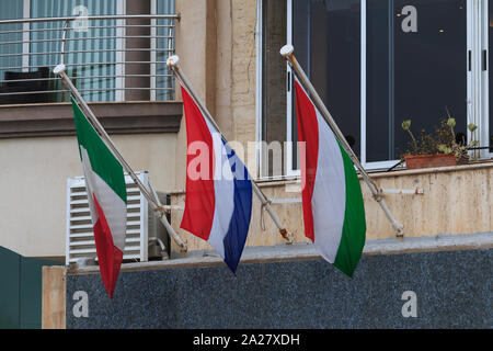 Italien Niederlande Ungarn Flaggen hängen an einer Wand in Malta Stockfoto