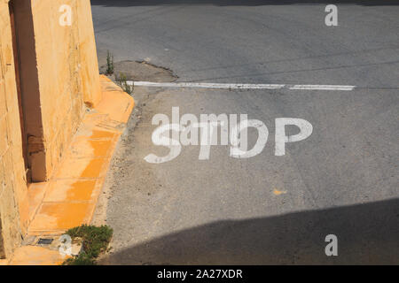 STOP Pflaster Kennzeichnung auf der Straße in Malta, Insel Gozo, Linksverkehr Stockfoto