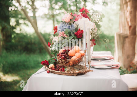 Weintrauben und Pfirsiche in eine Frucht Vase auf dem Tisch Stockfoto