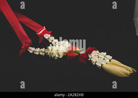 Einem ausgewählten Schwerpunkt traditionelle thailändische Jasmin Girlande. Symbol der Muttertag in Thailand, der Mönch oder Buddha in dunklen Hintergrund zu bieten. Stockfoto