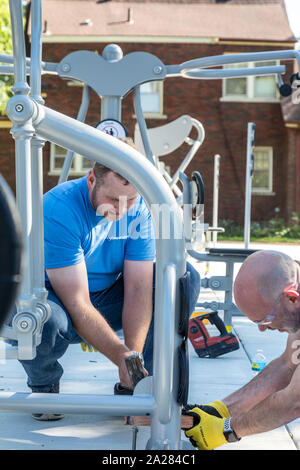 Detroit, Michigan - die Freiwilligen von Cooper Standard installieren Übung Ausrüstung in eine neue Gemeinschaft Morningside Park in der Nachbarschaft. Stockfoto