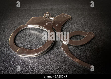 Handschellen Öffnen auf einem Schwarzen Tisch close-up Stockfoto