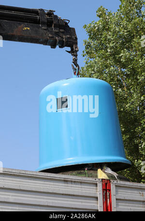 Blau Altglas recycling Container und der große Kran während der Sammlung Stockfoto