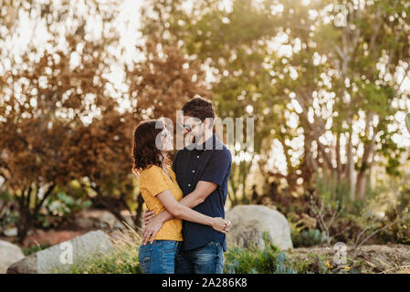 Portrait von Mann und Frau einander lächelnd und umarmen Stockfoto