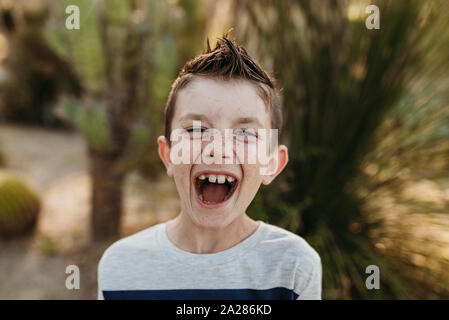 Close up Portrait von niedlichen kleinen Jungen mit Sommersprossen lachend im Freien Stockfoto