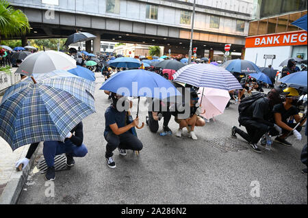 Hongkong, China. 01 Okt, 2019. Die Demonstranten hinter Regenschirmen während einer Konfrontation mit der Polizei in Hongkong am 1. Oktober 2019 verstecken. Foto von Thomas Maresca/UPI Quelle: UPI/Alamy leben Nachrichten Stockfoto