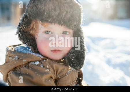 Portrait von Toddler boy im Winter Kleidung und Hut raus in den Schnee Stockfoto