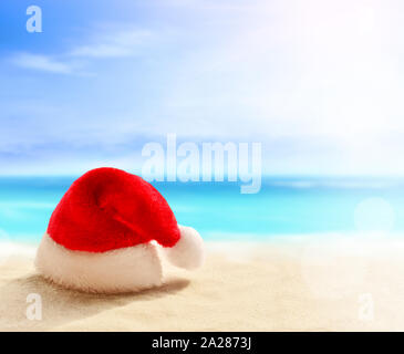 Weihnachten Konzept. Santa claus Hut auf Sommer sand Strand. Stockfoto