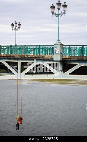 Weibliche Person auf einer Schaukel hängend auf einer Brücke, gruseliges Bild Stockfoto
