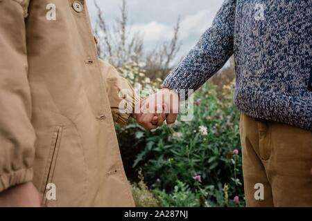 Nahaufnahme der Kinder draußen halten sich an den Händen Stockfoto