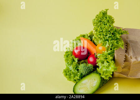 Bio Gemüse broccoli Gurken Paprika Äpfel in Braun aus Kraftpapier grocery Bag auf gelben Hintergrund. Gesunde Ernährung Ballaststoffe vegan Plas Stockfoto