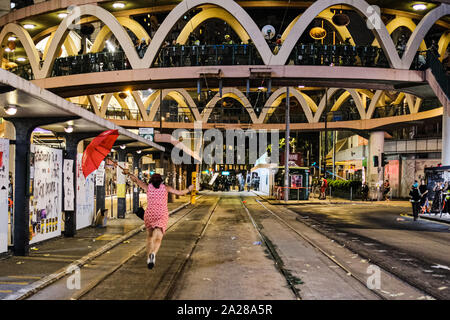 Hongkong, China. 1. Okt, 2019. Eine Frau mit einem Regenschirm Gebühren gegenüber der Polizei nach Pfeffer in Causeway Bay, Hong Kong gesprüht. Heute ist der 70. Jahrestag der Gründung der Volksrepublik China. Statt Hong Kong am 1. Oktober markiert den 70. Jahrestag als "Tag der Trauer" und Aktivisten der Demokratiebewegung Zusammenstößen mit der Polizei in der Stadt. Credit: Keith Tsuji/ZUMA Draht/Alamy leben Nachrichten Stockfoto
