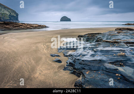 Trebarwith Strand North Cornwall mit der Ebbe mit dem Sand und Felsen an einem stürmischen bewölkten Tag ein sehr ruhiger Strand mit atemberaubenden Landschaften in Großbritannien Stockfoto