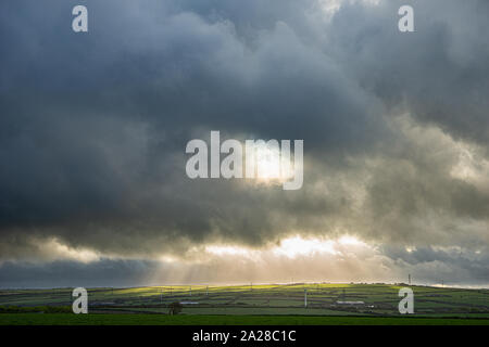 Stürmischen Himmel über Cornwall mit einem Bruch in den Wolken Hervorhebung Pylone Stockfoto