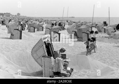 Strandkörbe im dem Strand an der Nordseeküste, Deutschland 1960er Jahre. Strandkörben an der Nordsee, Deutschland der 1960er Jahre. Stockfoto