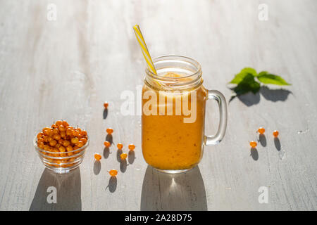 Frische organische gelb Smoothie in Glas mug auf weißem Holz- Tabelle, aus der Nähe. Erfrischende Sommer Obst trinken. Das Konzept der gesunden Ernährung. Meer buckthor Stockfoto