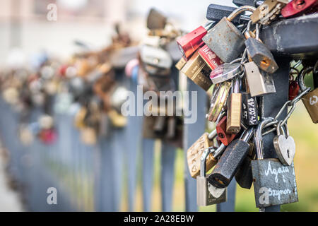 Ein Haufen rostigen Liebe Vorhängeschlösser an der Brücke befestigt. Stockfoto