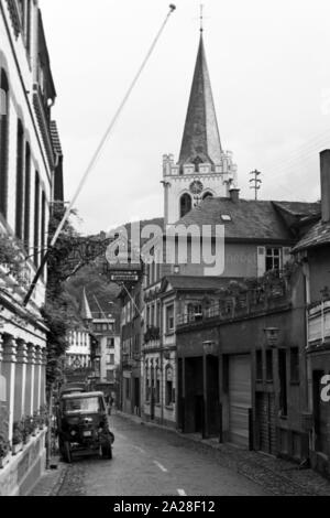 Hotel Gelber Hof" mit der evangelischen Kirche St. Petrus in der Blücherstrasse in Bacharach, Deutschland 1968. Hotel Gelber Hof" und die Evangelische Kirche St. Peter auf Bluecherstrasse Straße in Bacharach, Deutschland 1968 Stockfoto