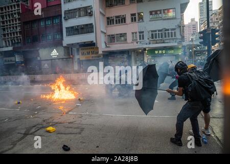 Tränen Gas von der Polizei gegen die Demonstranten eingesetzt wurden, als die Demonstranten werfen Benzinbomben in Richtung der Polizei während des Protestes. Eingabe der 18. Woche der Unruhen, Demonstranten marschierten am Morgen von Chinas nationalen Tag, den der 70. Jahrestag der Volksrepublik China feiert in diesem Jahr. Die Demonstranten skandierten Parolen und fuhr fort zu Fragen für die fünf Forderungen erfüllt werden. Die Demonstranten zu Zusammenstößen zwischen Polizei und wurden mit Gas, Gummigeschossen und Wasserwerfern und schließlich viele wurden festgenommen. Stockfoto