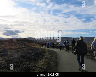 Touristen folgen dem Weg durch die vulkanische Landschaft die beeindruckende Godafoss fällt, einer von Islands Wasserfall Highlights zu erreichen. Stockfoto