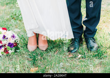 Cute 7/8 Bild von Schuhe Bräutigam und Braut gemeinsam auf dem Rasen. Stockfoto