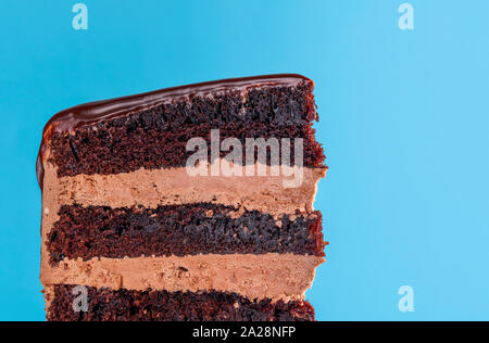Birthday Cake Slice mit Schokoladenfüllung. Close-up von Schokolade geschichteten Kuchen mit buttercream Vereisung. Makro mit Schokolade Zuckerguss Geburtstagstorte Stockfoto