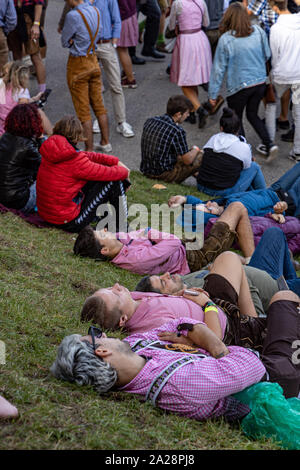 München, Deutschland, 2019 September 19:4 mans in einer Reihe schlafend auf dem Rasen an der Bayerischen Oktoberfest in München Stockfoto