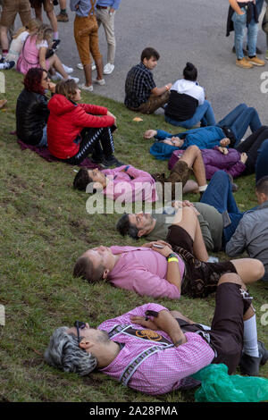 München, Deutschland, 2019 September 19:4 mans in einer Reihe schlafend auf dem Rasen an der Bayerischen Oktoberfest in München Stockfoto