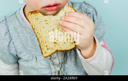 Kinder mit schlechter Ernährung. Kind essen Weißbrot. Kinder schlechte Essgewohnheiten. Stockfoto