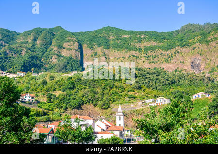 Malerisches Bergdorf Sao Vicente Madeira, Portugal. Die kleine Stadt ist von grünen Hügeln umgeben. Terrassierten Feldern, Felsen, hügelige Landschaft. Portugiesische Insel im Atlantischen Ozean. Stockfoto