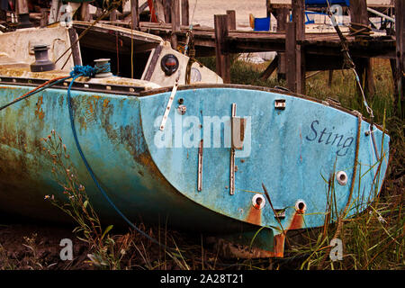 Ein Boot namens Sting an Land auf dem grasbewachsenen Ufer des Flusses Wyre, erinnert der Felder der Gold Stockfoto