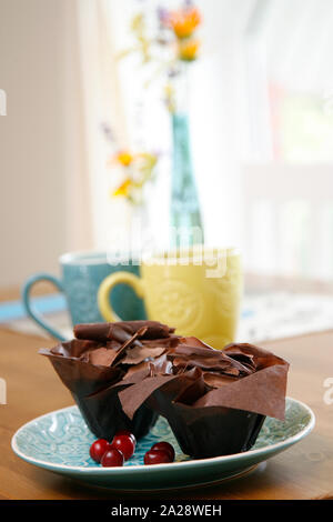 Zwei chocolate Cupcakes mit Chocolate Chips auf einem blauen Platte abgedeckt. Romantisches Frühstück für zwei. Stockfoto