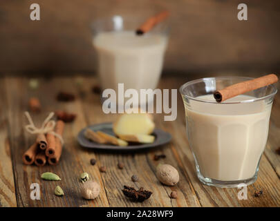 Masala Tee in ein Glas. traditionellen indischen trinken Masala Chai Tee mit Milch und Gewürzen Zimtstange, Grüner Kardamom, Sternanis, Ingwer. Selektive konzentrieren. Stockfoto