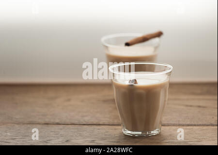 Indische Masala Tee mit Zimtstangen in zwei Gläser auf Holz- Hintergrund. Selektive konzentrieren. Natürliches Licht. Horizontal mit kopieren. Stockfoto