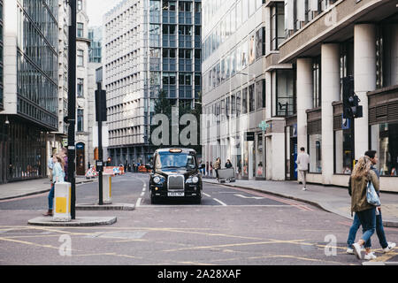 London, Großbritannien - 07 September, 2019: Black Cab warten auf Ampel auf einer Straße zwischen moderne Bürogebäude in der City of London, London's berühmten f Stockfoto