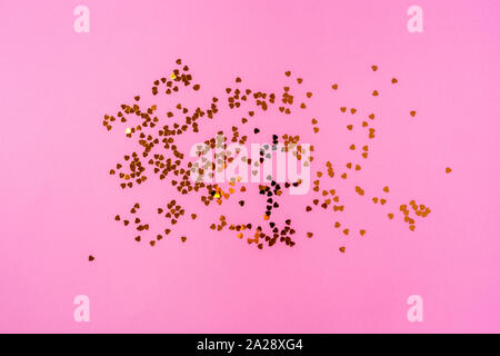 Golden glitter funkelt auf Rosa pastell Hintergrund. Stockfoto