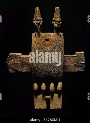 Ein traditionelles, geschnitztes hölzernes Granary Door Lock aus dem 19. Bis frühen 20. Jahrhundert mit zwei Ahnenfiguren, eingeschnittenen geometrischen Kreuzschraffuren und einem verschiebbaren horizontalen Kreuzbolzen, der von den Dogonen in Mali, Westafrika, geschaffen wurde. Stockfoto