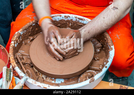 Der Bildhauer in der Werkstatt macht eine Kanne aus Steingut Nahaufnahme. Die Twisted Töpferscheibe. Stockfoto