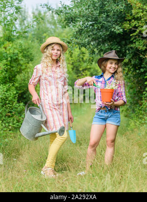 Diese Blume ist Ihre. Landwirtschaft und Landwirtschaft. Feder Land. Tag der Erde. Sommer Familie Bauernhof. Kinder Gartengeräte halten. kleine Mädchen Bauer im Dorf. Ökologie und Umweltschutz. Stockfoto