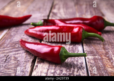 Frische rohe red hot chili peppers auf einer hölzernen Hintergrund Stockfoto