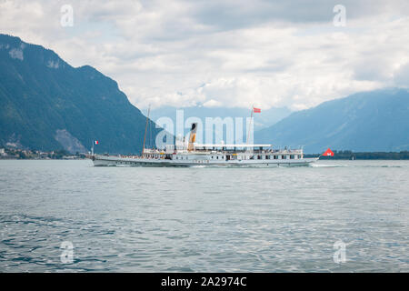 Traditionelle Passagier Paddelboot namens Italie Kreuzfahrt auf dem Genfersee (Lac Leman) Entlang der Schweizer Ufer mit den Alpen im Hintergrund Stockfoto