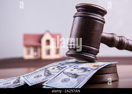 Modell von Haus auf Geld us-Dollar mit der Richter Hammer als Anlagekonzept Hypothek fonds Finanzen und Risiko der Investition. Stockfoto