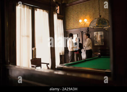 Drei Kollegen in einer Diskussion in einem Pool Hall. Stockfoto