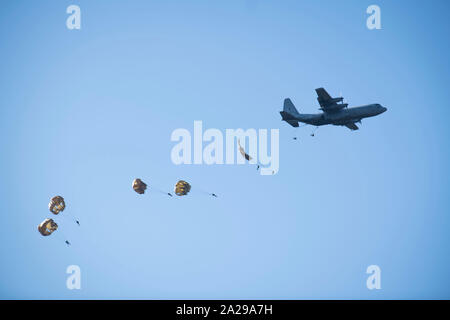 Fallschirmjäger aus mehreren alliierten Nationen einschließlich der Vereinigten Staaten, von der Royal Netherlands Air Force C-130 Hercules während eines multinationalen Gedenkmünze Betrieb springt. Drop Zone Ginkel, außerhalb von Arnheim, Niederlande, Sept. 21, 2019. Hunderte von Fallschirmjäger bei Markierung des 75. Jahrestages der Operation Market Garden, die Auszeichnung für die alliierten Soldaten, die in der historischen Betrieb mit mehreren niederländischen Städten befreit beteiligt waren. (U.S. Armee Foto von SPC. Christopher Brecht) Stockfoto