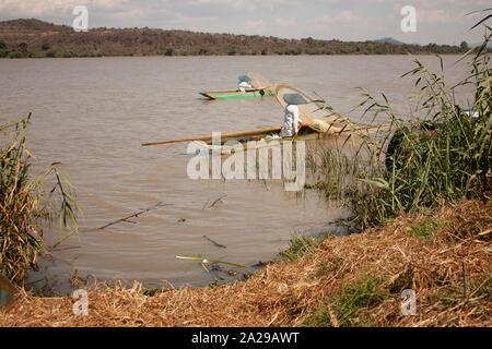 Paar Fischer tragen weiße Decken und paddeln Hüte Segeln mit ihren Kanus beladen mit Moskitonetzen über See bedeutet trocken Cob Stockfoto