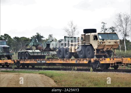 Militärische Fahrzeuge und Ausrüstungsgegenstände von der 829th Engineer Unternehmen sind auf triebwagen Sept. 27, 2019 geladen, am Fort McCoy, Wis die Ausrüstung für einen Einsatz in Übersee im Jahr später ausgeliefert wurde. Die Schiene wird geladen und die damit verbundenen Arbeiten wurde von der 829Th und Mitarbeiter mit der Festung McCoy Logistics Readiness Center Transport Division abgeschlossen. (U.S. Armee Foto von Scott T. Sturkol, Public Affairs Office, Fort McCoy, Wis.) Stockfoto