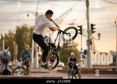 Der Kerl auf dem BMX springt auf die Brüstung. Stockfoto